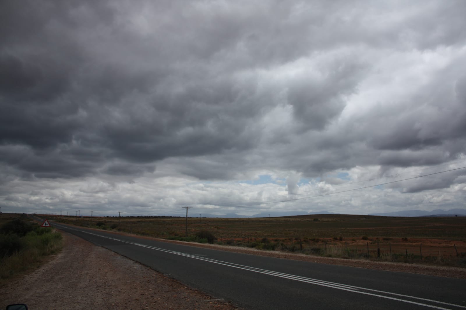 Gerade Landstraße unter dunklen Wolken