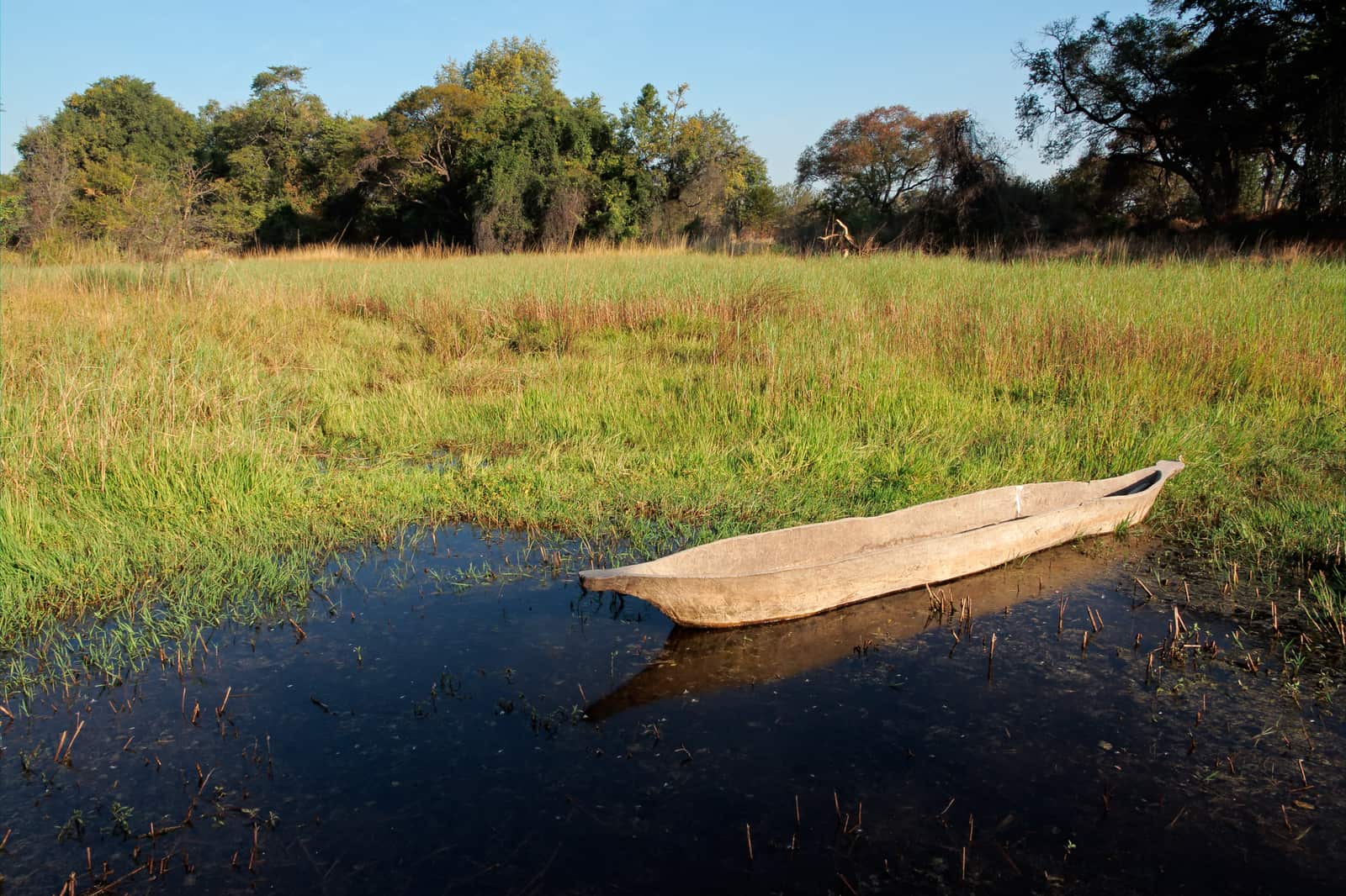 Hölzerner Einbaum im flachen Wasser der Sambesi-Region